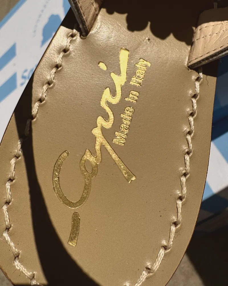 Primo piano della suola di un sandalo con la scritta dorata «Capri, made in Italy»